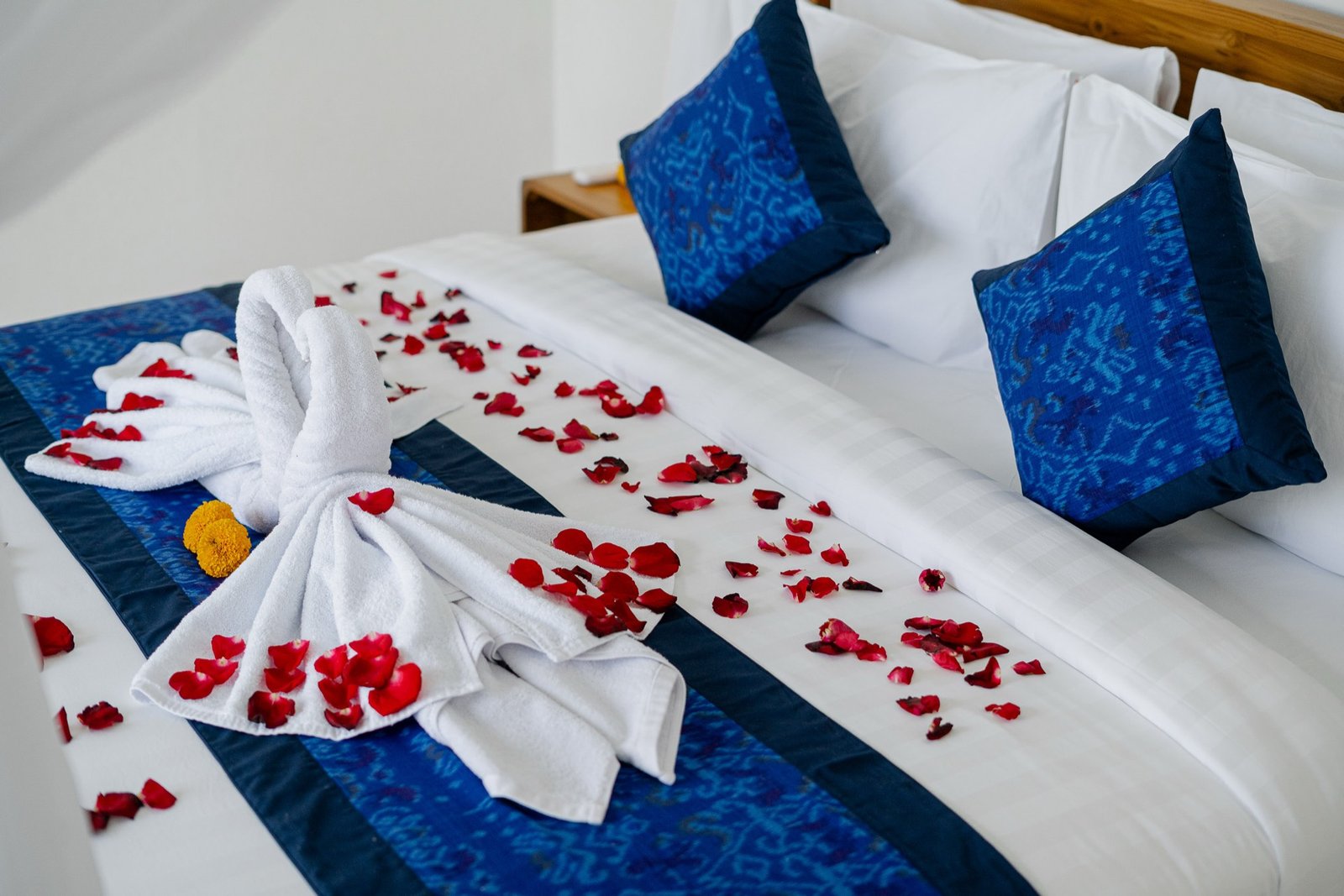 Cahyana Tibuah - swan towel art and rose petals on the bed