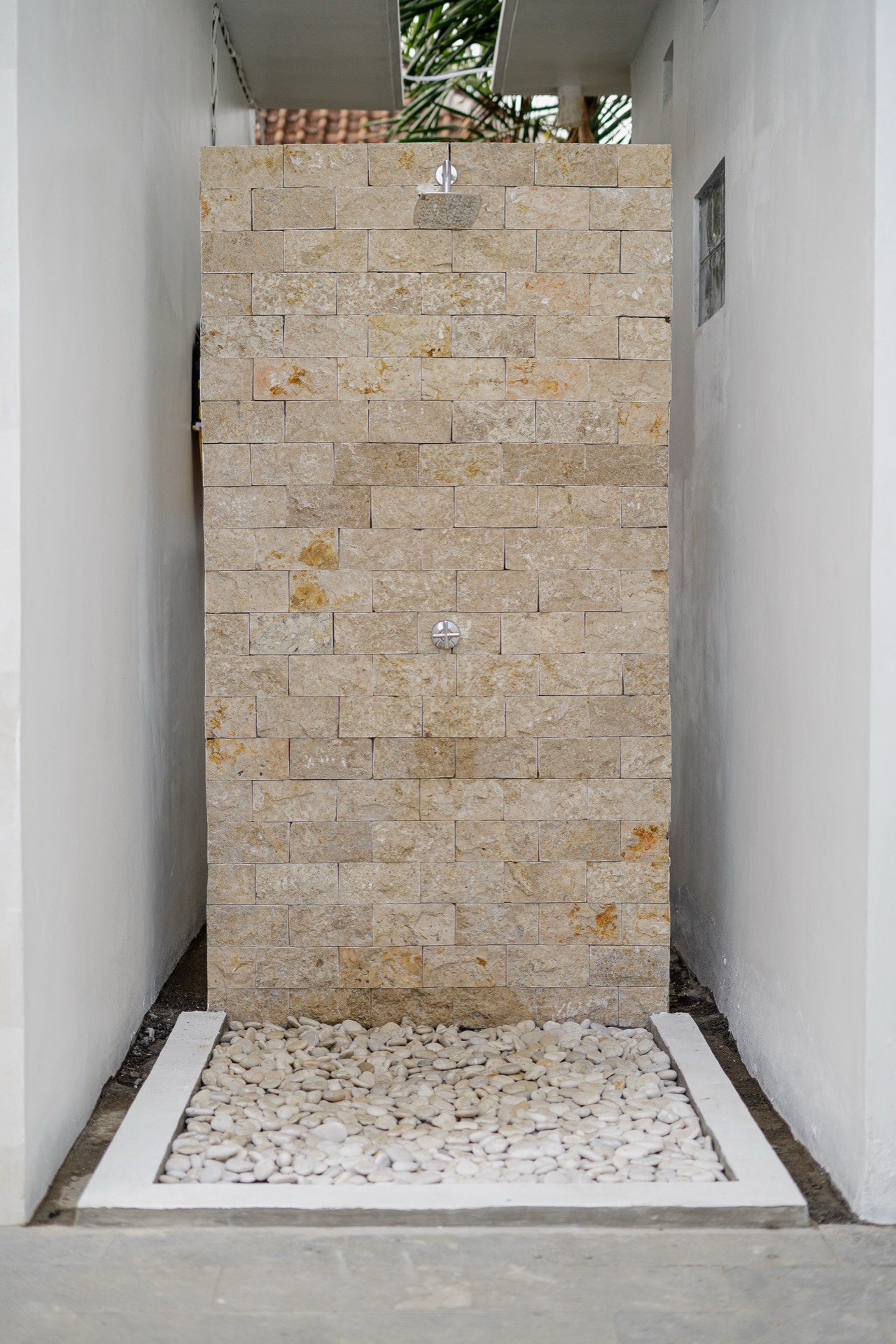 Cahyana Tibuah - the outdoor shower against a stone wall