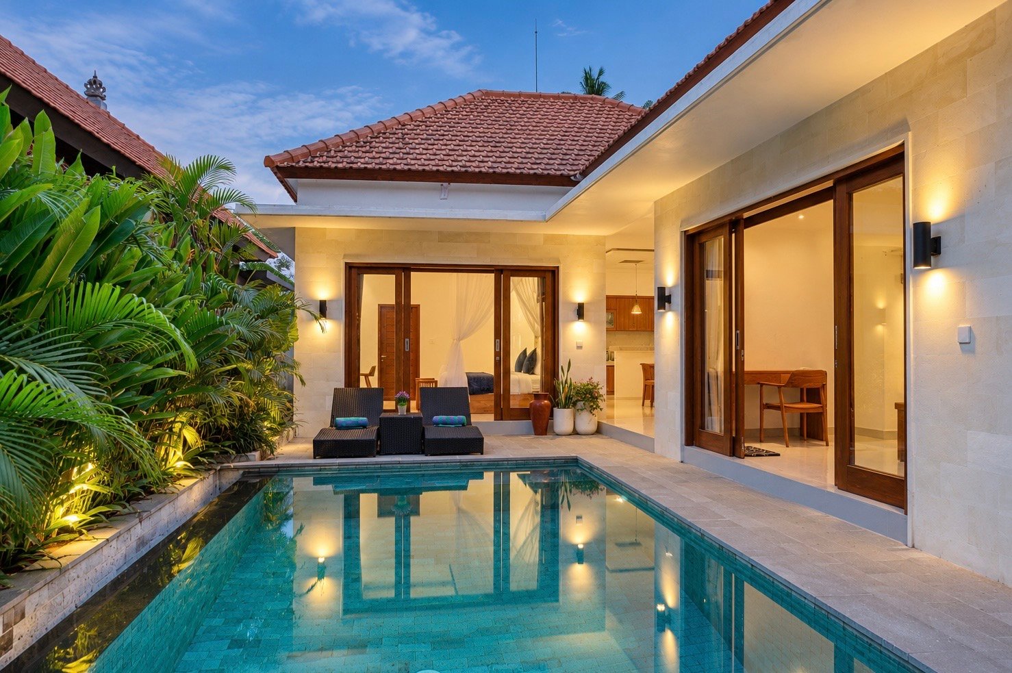 Cahyana Tibuah private pool at dusk with the lit villa and sun loungers